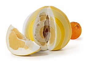 Large ripe pomelo fruit with a cut out piece and orange  on a white background. Full depth of field.