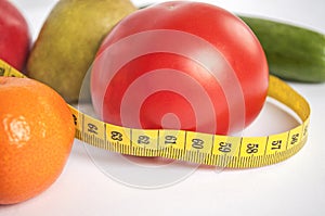 Large ripe tomatoes and other vegetables, fruits with a measuring tape. Healthy Eating
