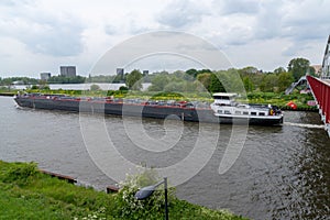 Large riverboat barge tranporting goods along the wide canals of Amsterdam