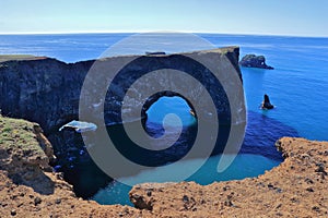 Large Rock Arches jutting into the Atlantic Ocean, Dyrholaey near Vik i Myrdal, South Coast of Iceland photo