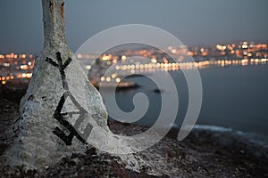 Large rock formation with text inscribed on its surface sits on the coast of an ocean photo