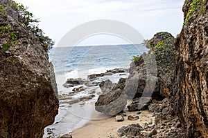 Large rock formations on sandy beach with blue sea in the background in Puerto Rico