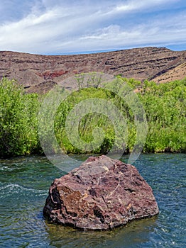 A large rock lodged in the middle of the Owyhee River in Oregon, USA