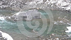 large rock sitting in the middle of a river, rapid flow of a mountain river