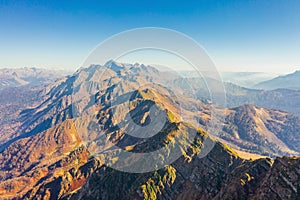 Large rocky mountain range with peaks and troughs, aerial view on a clear sunny day with good weather photo