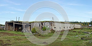 A large room for cattle hoton, made of cow dung and wood, overgrown with grass stands, abandoned on a plot with a house