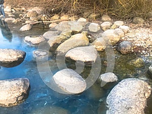 Large round beautiful natural stones cobblestones in water, sea, lake, river. Background, texture