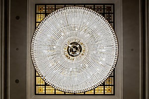 Large round chandelier with crystals and candlesticks on the ceiling, dark background, retro style. Beautiful chandelier in luxury