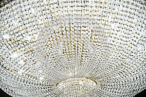 Large round chandelier with crystals and candlesticks on the ceiling, dark background, retro style. Beautiful chandelier in luxury