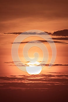 large round orange sunrise or sunset with texture of cloudy sky for background