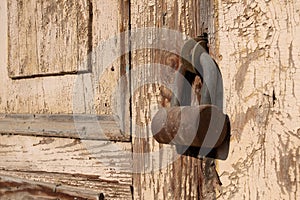 Large round shaped lock hanging on rusty hinges