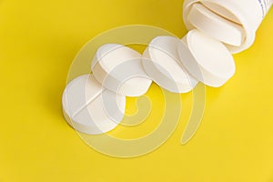 Large round tablets scattered on a yellow background