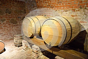 Large round wooden barrels for beer, wine in the old cellar of the Middle Ages made of brick