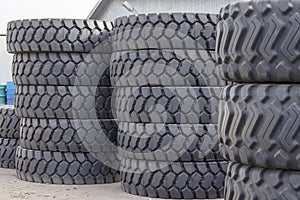 Large rubber tires for trucks lying on the street. Many close-up tires with a large tread are lying