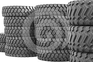 Large rubber tires for trucks lying on the street. Many close-up tires with a large tread are lying on the ground