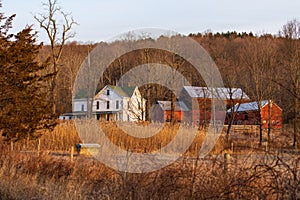 Large rural country home and red barn in dry winter landscape