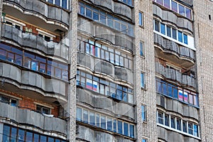 large russian apartment building balcony windows with russian tricolor flags