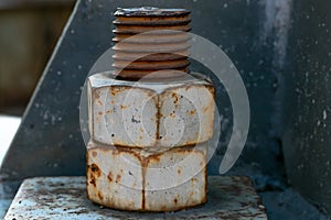 A large rusted bolt with screw. Part of a huge metal construction.