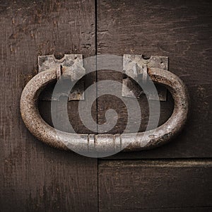 Large rustic door knocker, vintage metal on an old wooden door.