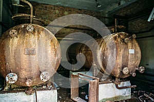 Large rusty iron barrels in an abandoned factory. Abandoned industrial