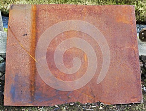 Large rusty iron sheet on a rustic courtyard