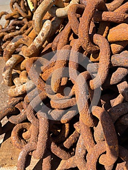 Large rusty metal chains on quayside