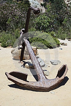 Large, rusty old boat anchor on the beach