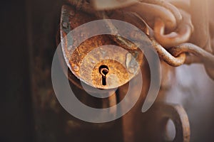 A large rusty padlock and a rusty metal chain close the old door. Secret