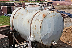 Large rusty steel barrel for technical water at construction site