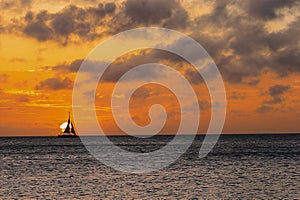 a large sail boat is out in the ocean at sunset