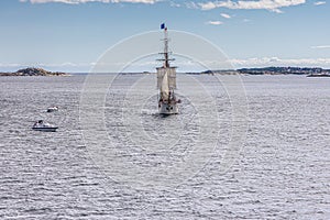 A large sailing frigate, barque or brig sails on a calm sea