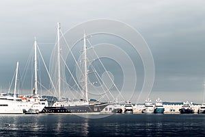 Large sailing yacht among the smaller yachts at the marina