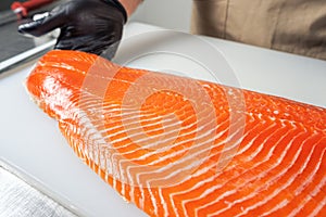 A large salmon awl on a white chopping Board