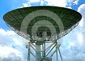 Large satellite dish with cloudy sky for telecommunications and broadcasting