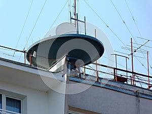 Large satellite dish receiver on flat roof of tall condo building