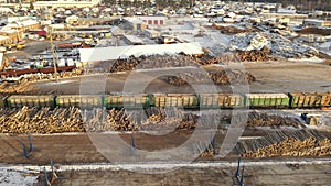 A large sawmill located in village aerial view. Modern woodworking factory with a railway junction