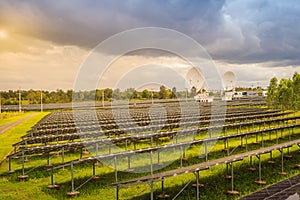 Large scale solar farm with the satellite dishes under dramatic