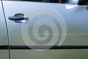 A large scratch on the door of a silver car. Concepts- accident, car insurance, traffic accident.
