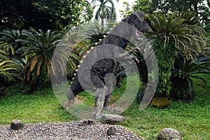 Large sculpture of a tyrannosaurus rex dinosaur in the garden