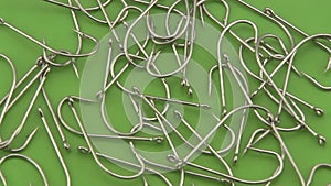 Large sea angling, fishing hooks rotating on a green background.