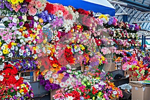 Large selection of artificial flowers and bouquets in the market.