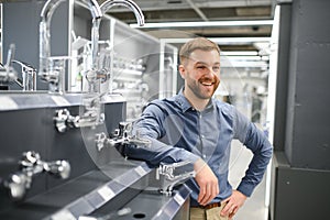 A large selection of water faucets. Man chooses a products in a sanitary ware store