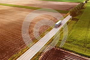 Large semi-truck on countryside road seen from drone pov, aerial shot of trucking and logistics concept