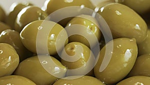 Large shiny green olives macro background