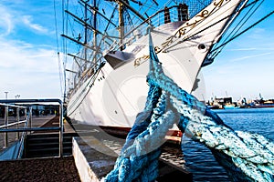 A large ship is moored with ropes.