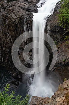 A large single drop waterfall cascading into the river below