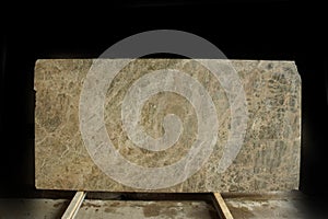 A large slab of natural beige stone with small veins is called Emperador Light marble