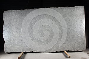 A large slab of natural gray stone with dark dots is called granite Bianco Cristall photo