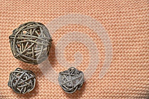 Large and small balls of rattan on knitted fabric. Beig background. View from above. Copy space, flatlay.