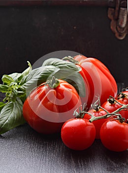 Large and small tomatoes with basil